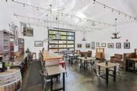 Image of rollup garage door with inside tables and chairs for seated tastings
